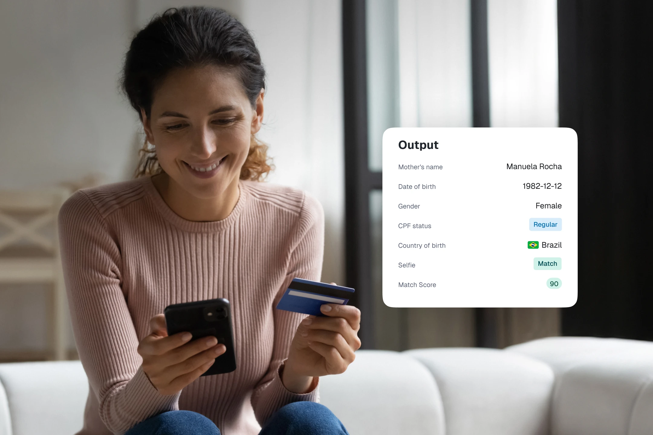 Smiling woman on a sofa holding a phone and a bank card, with an "Output" data card floating on the right